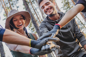 Teamwork concept. Group of friends during collecting trash in forest
